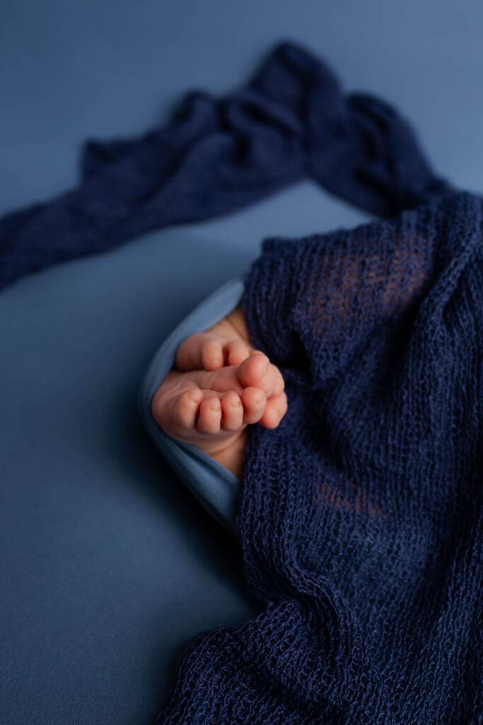 Studio-style newborn portrait with neutral backdrop and soft wrap in Nashville home