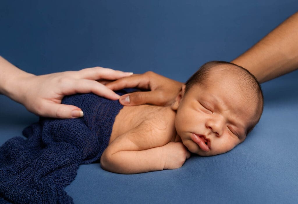 Baby posed on professional backdrop stand during in-home newborn session