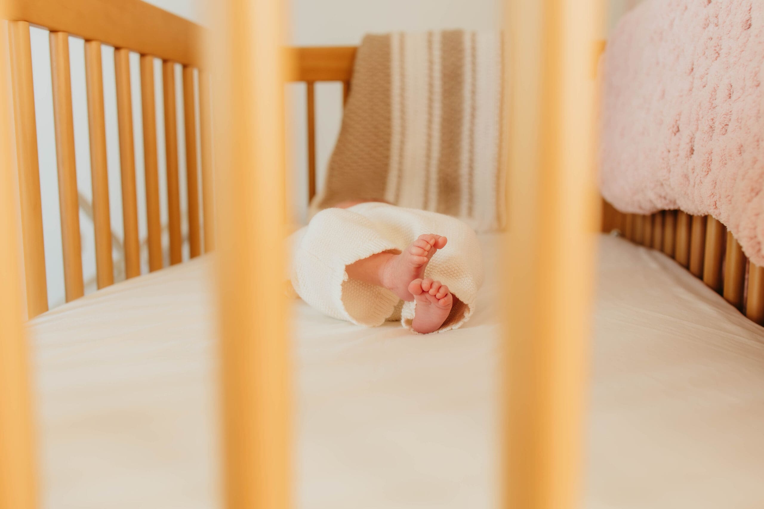 baby feet through crib during lifestyle photography session in Nashville