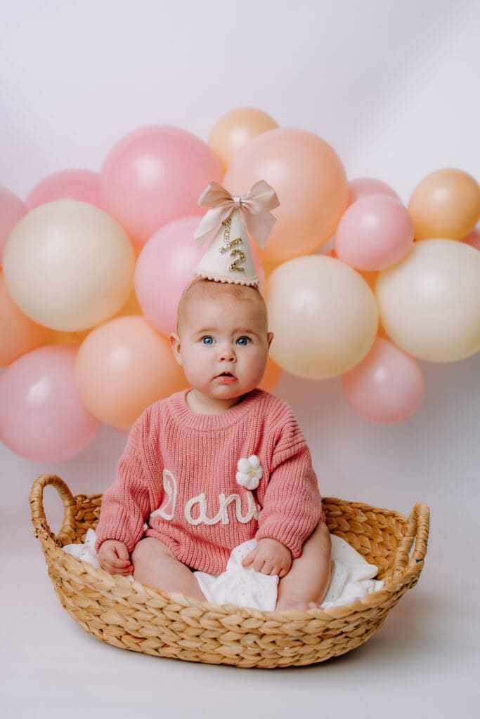 6 month baby sitting in basket with balloons for Nashville milestone photoshoot